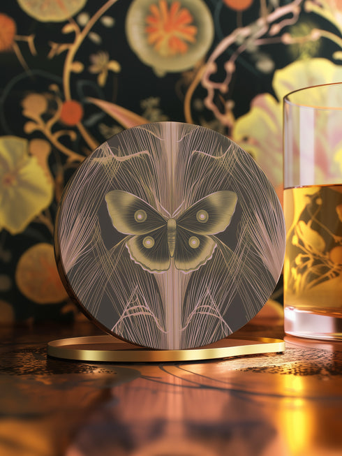Round ceramic coaster featuring golden Luna moth illustration on dark green background with rose gold linear patterns. Cork-backed, 4-inch diameter. Perfect for vintage nature and gothic decor enthusiasts.